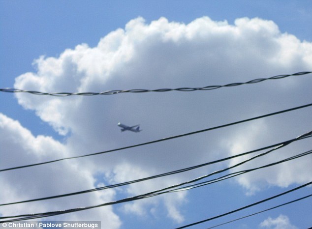 Blue sky thinking: Christian, 7, looked up and snapped this aeroplane flying over some telephone wire