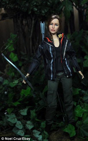 Doppelgangers: Artist Noel Cruz took a plan store-bought Katniss Everdeen Barbie (left) and transformed her into a life-like doll resembling Jennifer Lawrence in the Hunger Games (right)