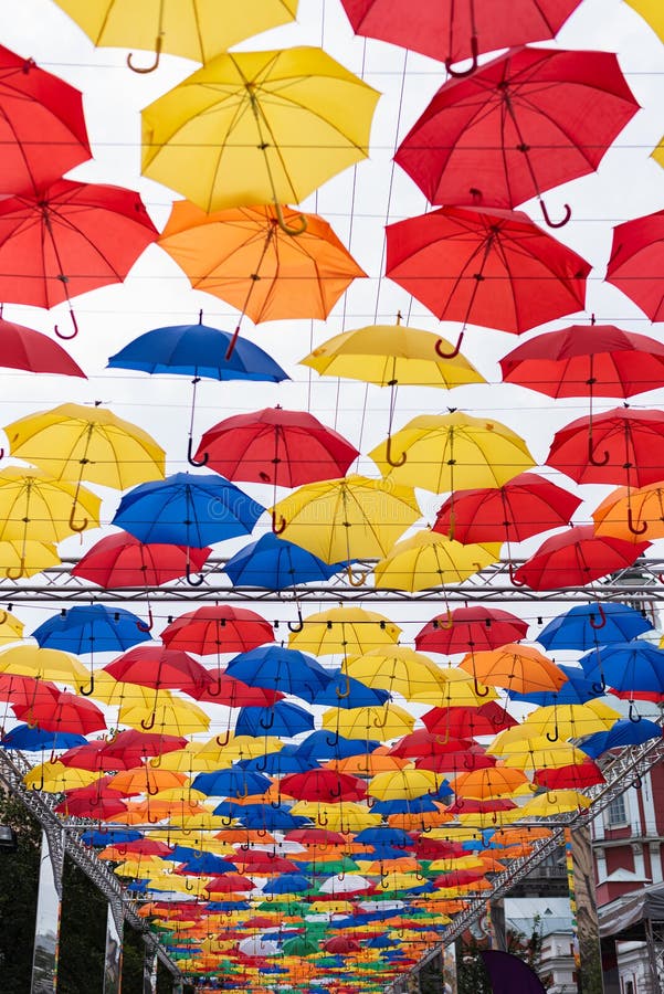 Many multi-colored umbrellas in the sky, unusual summer street scenery. Multi-colored umbrellas in the sky, unusual summer street scenery royalty free stock photos