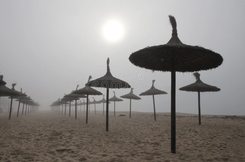 Unusual Fog in el arenal beach in mallorca. Rare and unusual heavy fog over the coast with sun umbrellas of El Arenal beach touristic area during winter in the stock photo