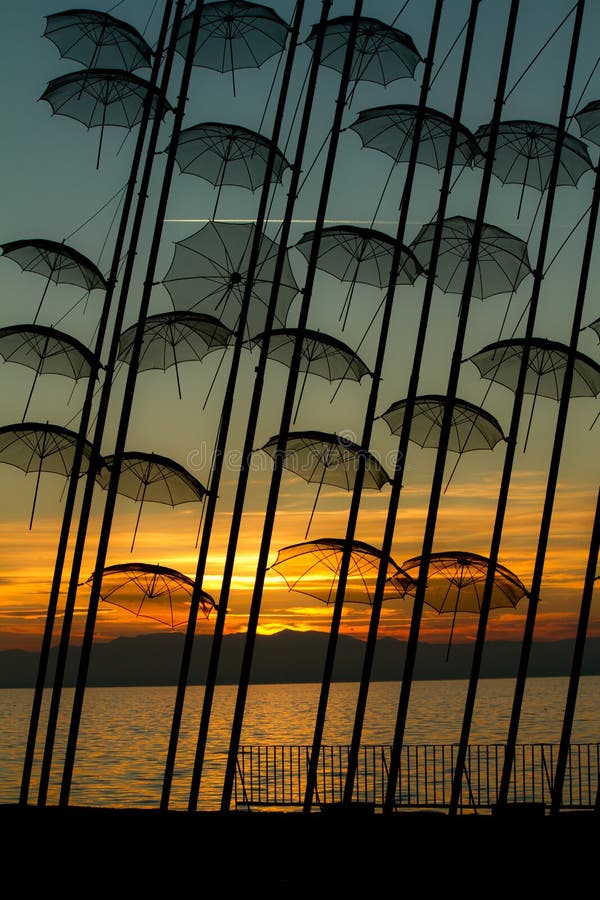 Unusual umbrella sculptures. Unusual umbrellas by sea with golden sunset in background, Thessaloniki, Greece royalty free stock photography